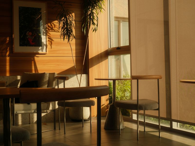 Modern outdoor dining pavilion with motorized Phantom screens lowered across wide openings, revealing forest view beyond.